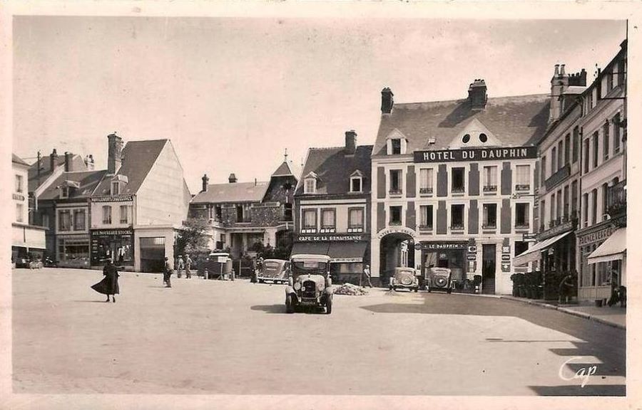 1930er. Auf dem Place de la Halle steht auf der rechten Seite vor dem Hotel du Dauphin ein 201 D