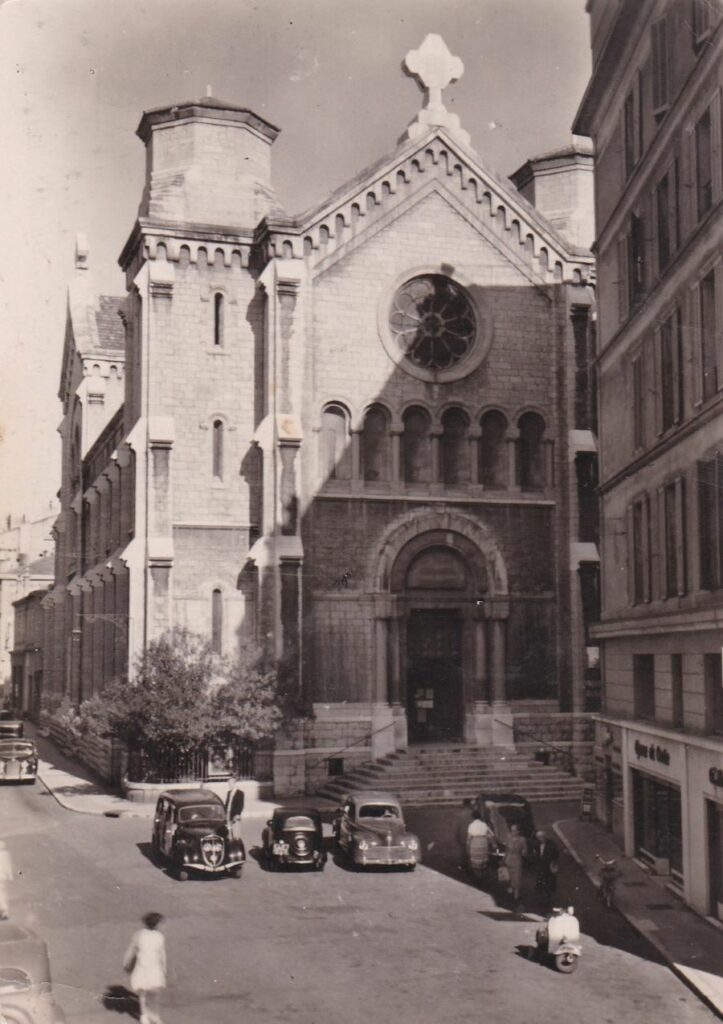 Wieder 1950er. Vor der Eglise du Bon Voyage parkt links ein Peugeot 202 Comercial