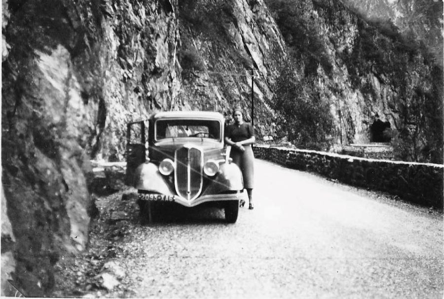 1930er. Das Befahren der Alpenpässe war noch ein echtes Abenteuer. Hier lässt sich die stolze Pilotin neben ihrem Peugeot 301 auf der Strasse zum Col de Lautaret ablichten