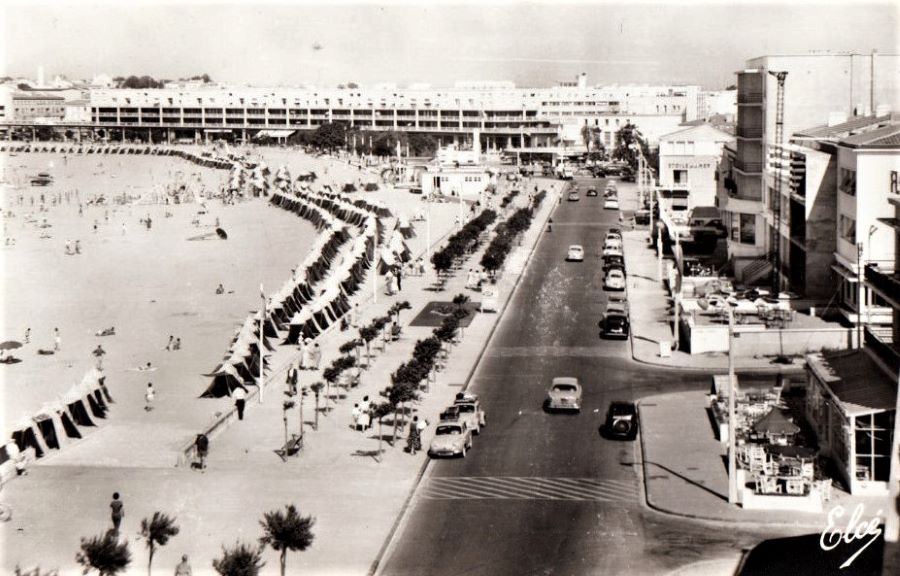 1964. An der Strandpromenade steht rechts vorn ein Peugeot 202