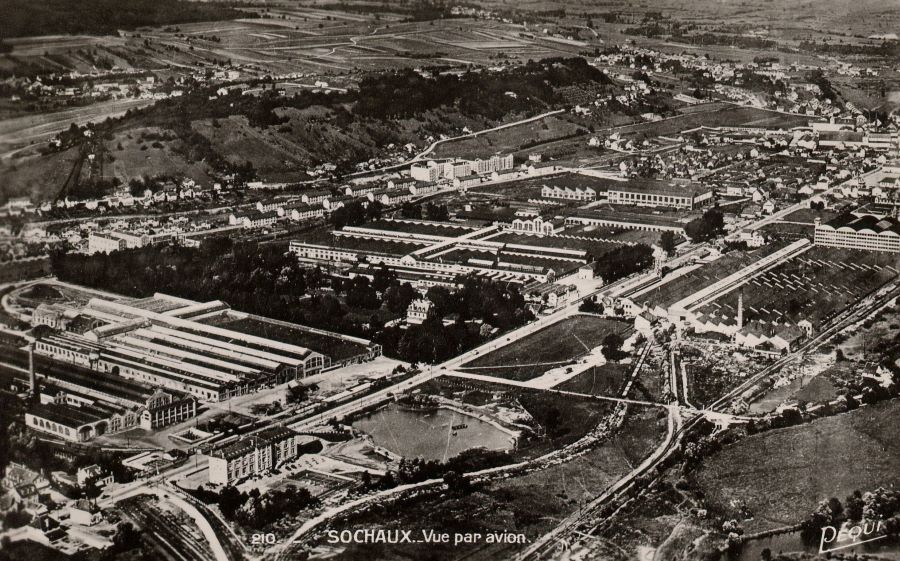 Vermutlich 1960er-Jahre. Luftbild des Peugeot-Werkes in Sochaux. Vorn links das Cercle-Hotel und die Freifläche, auf der sich heute das Musee Peugeot, die dazugehörigen Parklplätze und die Museumswerkstätten etc. befinden.