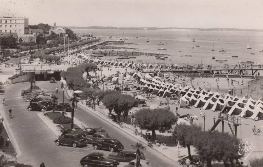 1950er. Blick auf Strand und Promenade. In der rechten Reihe zunächst 4 x Peugeot 203, der 5. Wagen ist wohl ein 302.