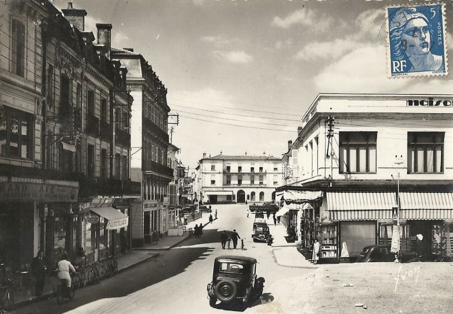 1930er. In der Rue Leon Gambetta parkt mittig entgegen der Fahrtrichtung ein Peugeot 402